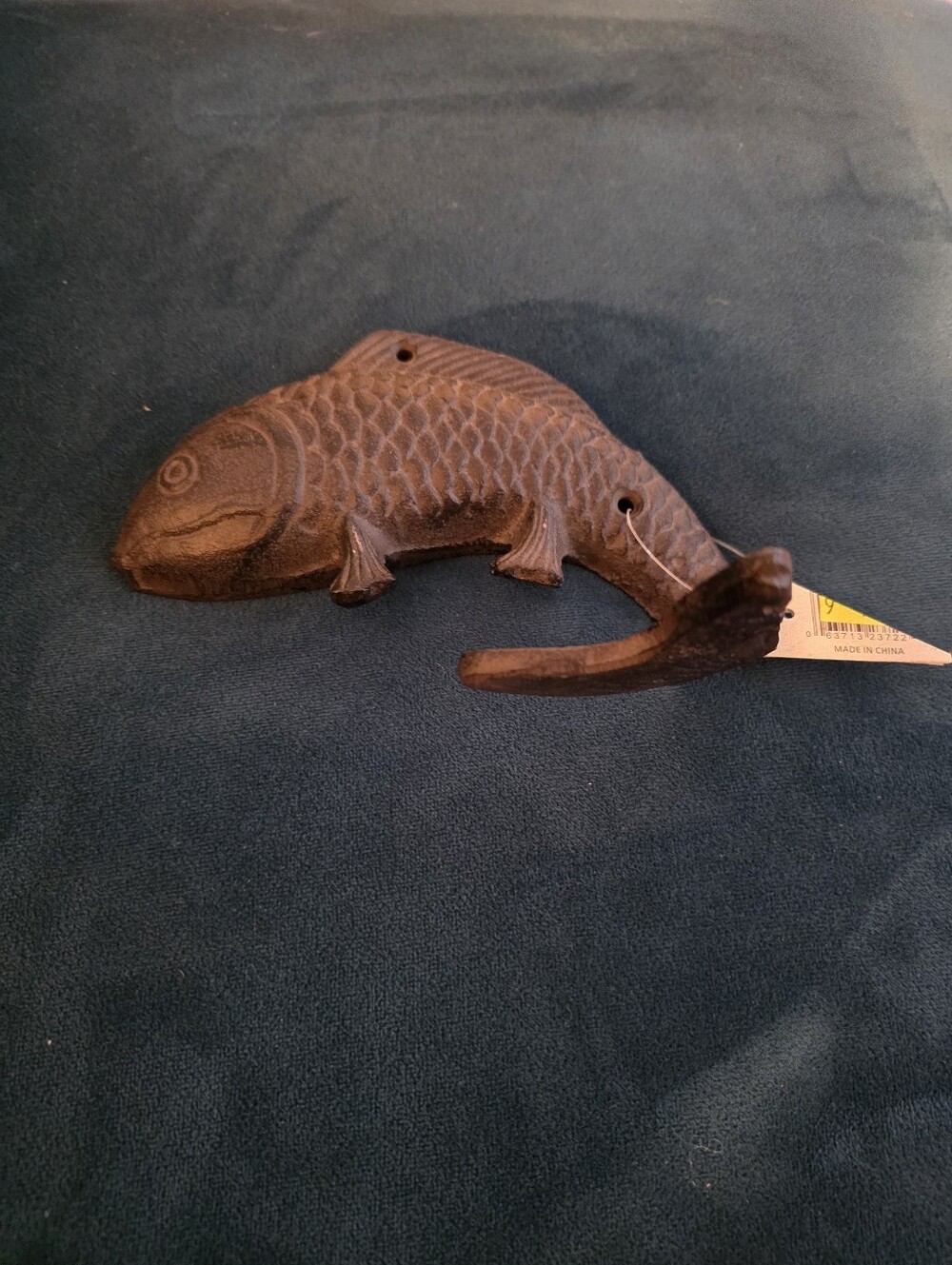 Decorative, brown-finished cast iron fish wall hook with an upturned tail